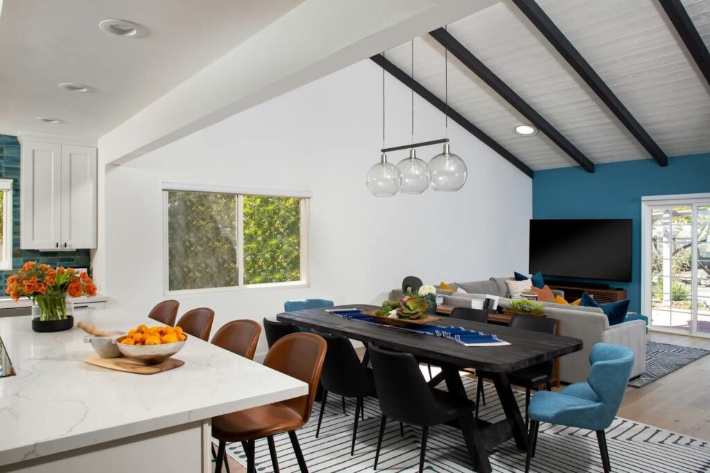 Spacious open-plan interior design combining kitchen, dining, and living areas with modern furniture.