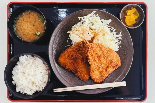 a plate of food with rice, meat, and sauces