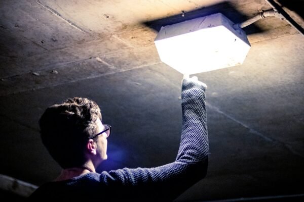 man holding lighted ceiling light