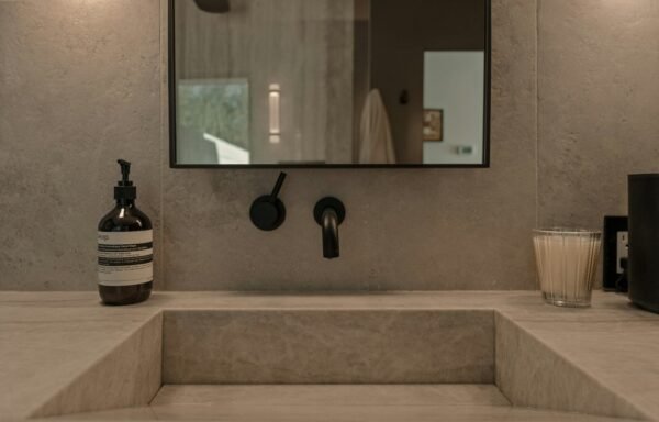 Modern bathroom sink with soap dispenser and candle.