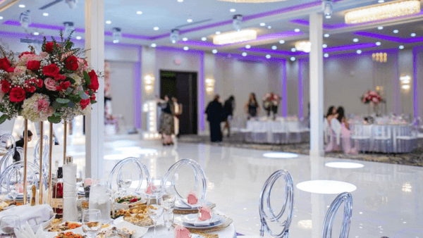 Elegant-banquet-hall-with-floral-centerpieces-round-tables-and-ambient-purple-lighting-for-special-events.png